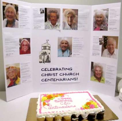 The centenarians’ photos and a cake greeted people as they entered the luncheon at Christ Episcopal on First Thursday to salute the centenarians. (photo by Eleanor Snite)