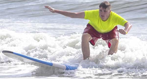 Surfer Fletcher Schaier rides a wave during the HEAL Riding the Wave of Autism event in Jacksonville Beach. (photo by David Rosenblum)