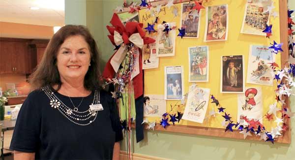 Janice Reaves, activities assistant at The Palms at Ponte Vedra Memory Care, displays nostalgic postcards for residents to enjoy. (photo by Chelsea Wiggs)