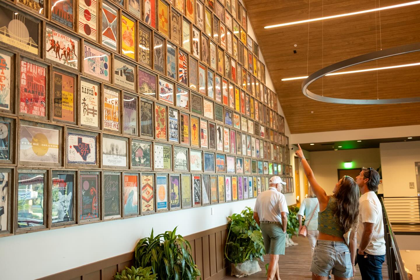 Visitors admire the Ponte Vedra Concert Hall's past performers as they are displayed on a wall within the building.
