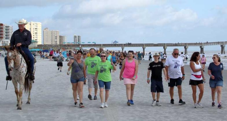 Eric Ryan Anderson, one of the founders of Spirit Equine Therapy, leads walkers on the beach. (photo submitted)