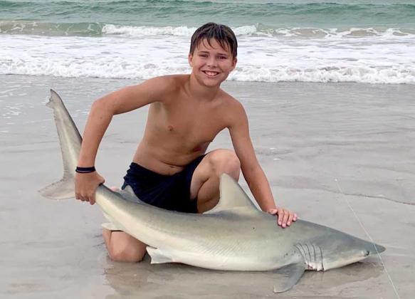 Atlantic beach resident Zane Wilson shows off his beach-caught sandbar shark. (photo submitted)