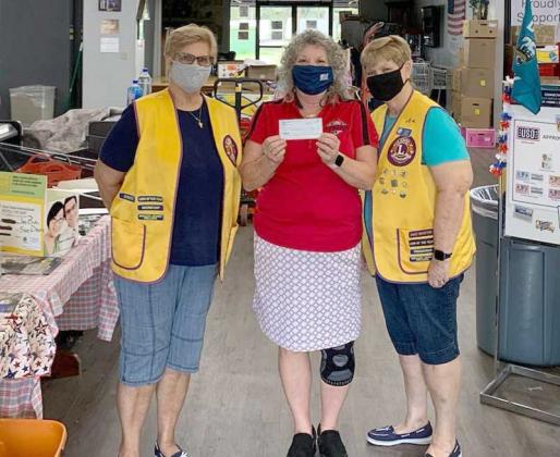 Lions Club members Pat Schaaf (left) and Sue Dixon (right) deliver a check to a Mayport USO representative. (photo submitted)