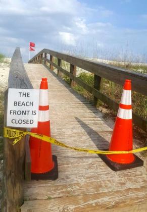 Beach access points are blocked off with various forms of barricades to inform the public of the current beach closures. (photo by Liza Mitchell)