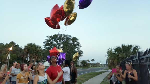 Kaitlyn Rozar, 12, releases balloons to honor her mother, Jeanie Rozar, during a vigil at the site where her mother died in a bus accident.