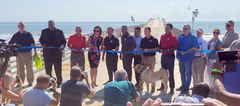 Officials from Jacksonville Beach and the city of Jacksonville cut the ribbon marking the reopening of the Jacksonville Beach pier July 6. (photo by Liza Mitchell)