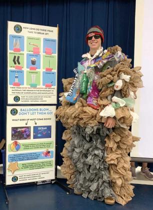 A member of the Ponte Vedra High School Go Green Club demonstrates the hazards of single-use plastics.