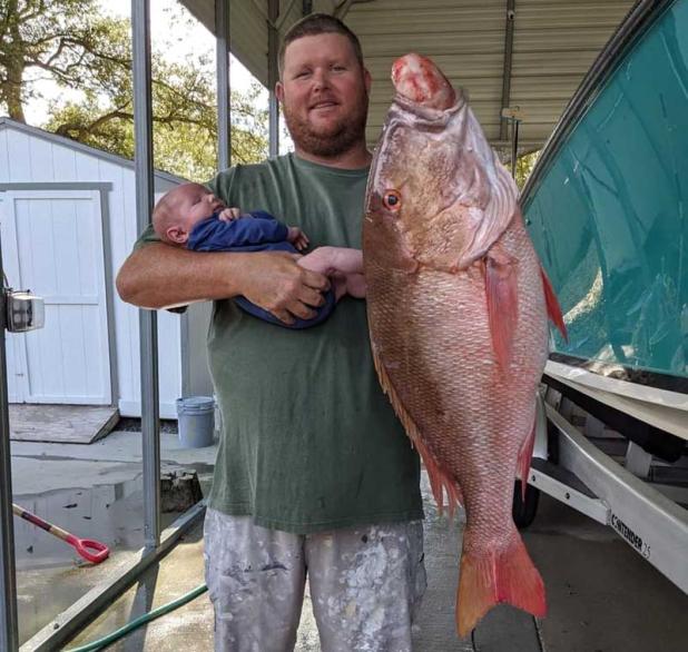 Frank Vining showing his son, Riley, what a healthy First Coast mutton snapper looks like. (photo submitted)