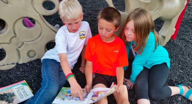 (From left) Levi Usry and Brody Kaul, second graders from Elizabeth McCall’s class, and Lyla Peters, a first grader from Neeti Gregg’s class, take part in a reading buddy program at Ocean Palms Elementary. (photo submitted)