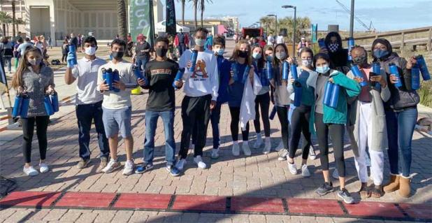 Volunteers for the Go Green Winter Beaches Run hold up the reusable water bottles that were this year's giveaway to participants at the end of the race. (photo submitted)