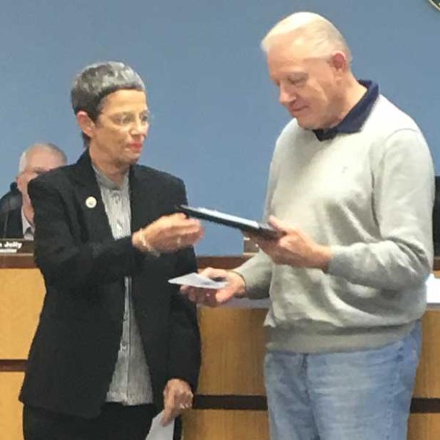 Neptune Beach Mayor Harriet Pruette presents a plaque to Richard Keene. (photo by Chelsea Wiggs)