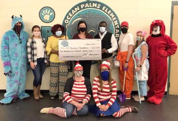 Staff at Ocean Palms Elementary School present members of the JT Townsend Foundation with a check from the student ambassador’s kindness card project. Shown are (back row) Michael Marimpietri; Lyndsey Smith; J.T. Townsend’s aunt, Pat Jackson, Executive Director Pauline Gerry; board member Carlos Zeigler; Kaleigh Kessler; Lee Serino; Tiffany Cantwell; (front row) Faie Pellegrino; and Jess Weeks.