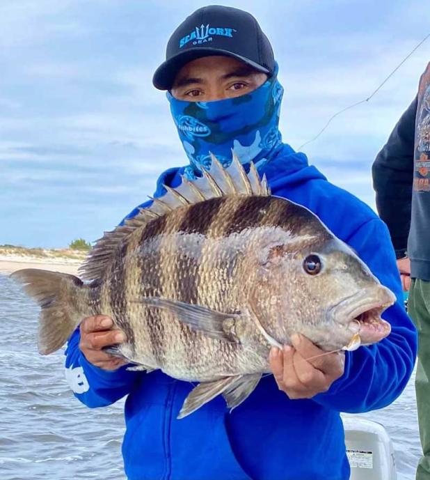 Para Ou put on the foul weather gear and pulled in a great sheepshead despite the tough conditions last weekend. (photo submitted)