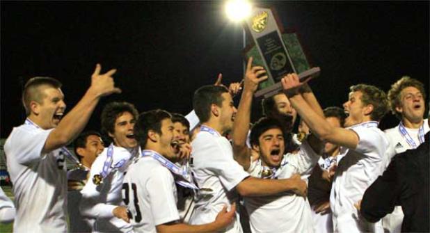 On the field at Melbourne High School, Ponte Vedra High players celebrate with the Florida High School Athletics Asso-ciation trophy after winning the Class 3A boys soccer state championship last Thursday. The Sharks defeated Immoka-lee 4-0 to complete a perfect season with a 25-0 mark. It was a second state title for the Sharks, who also won in 2013. (photo by Rob DeAngelo)