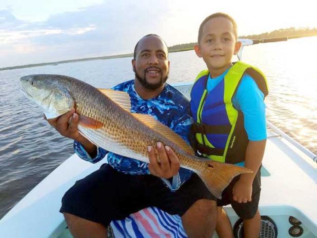 Eli Walfall and his dad, David, with a great redfish from the creeks. (photo submitted)
