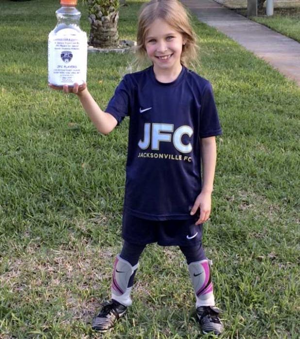 Seven-year-old Jessie Durden with a donation bucket for Small Steps. (photo by Julie Durden)