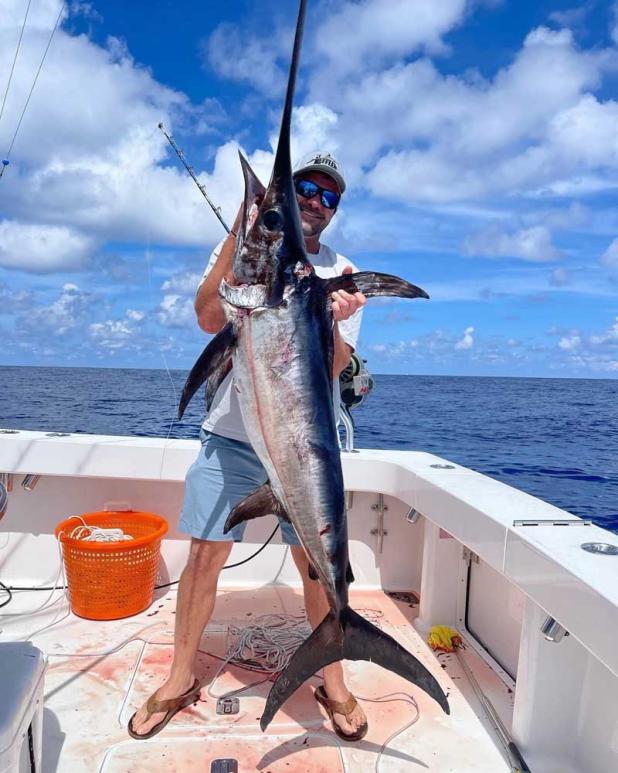 Capt. Brandon Ingalls and a daytime summer swordfish he put his clients on with Bluewaters Sport Fishing. (photo submitted)