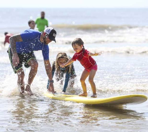 A Super Grom attendee gets a helping hand from instructor David Martin. (photo by David Rosenblum)