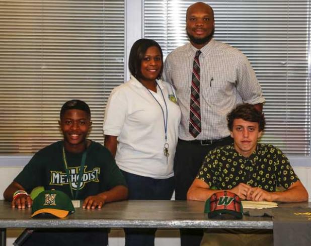 Randy Gadson (left) and Adler Guinn (right) pose with Carver Center representatives Latoya Thomas and Johnny O’Hara prior to signing scholarships to play college sports. O’Hara works for Parks and Recreation, and Thomas is the Carver Center Supervisor. (photo by David Rosenblum)