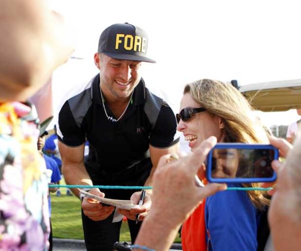 Tim Tebow signs autographs for fans. (photo by Rob DeAngelo)