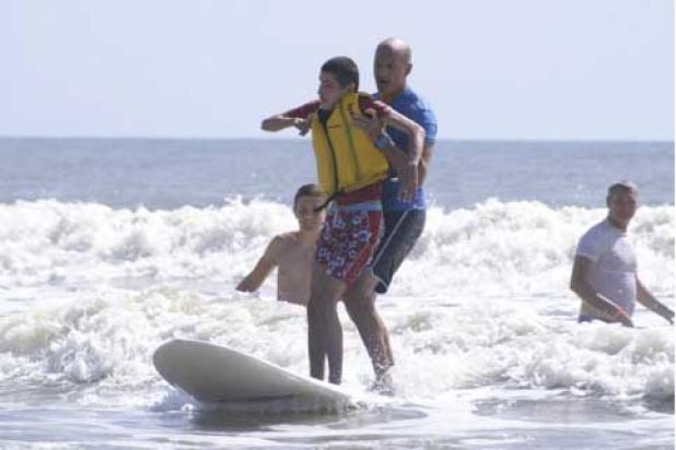 “Max,” a blind participant with autism, is assisted by volunteer Joe Matacia. (photo via greatpvpaddle.org)