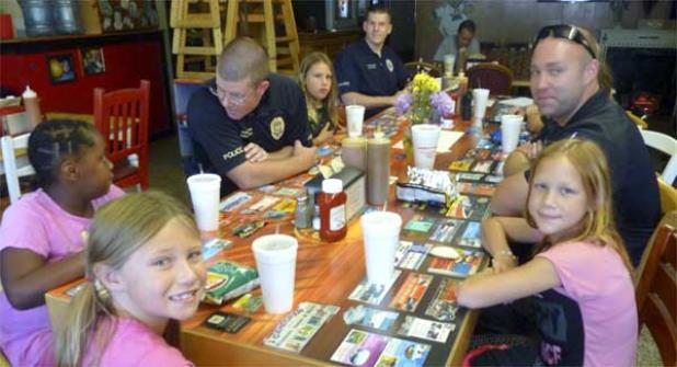 Jacksonville Beach Police Officers David Cohill, Benjamin Conner and Dustin Gibson have lunch with local kids Jamie and Honesty from The Boys and Girls Home of North Florida at Angie's Subs on July 25. (photo by Jessica Fondo)