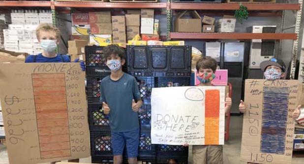 Jack Miller (second from right) and his friends holding posters with fund-raiser goals. (photo submitted)