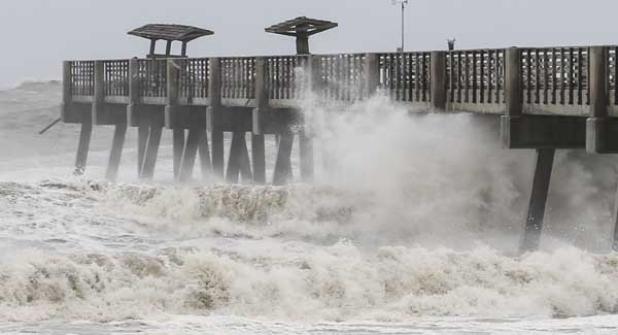 Waves produced by Hurricane Irma pound the Jacksonville Beach Pier hours after the storm passed through the area. The pier did not appear to suffer any more damage than it previously did during Hurricane Matthew in 2016, except for a few more boards getting knocked off the walkway. The damage from 2016 has not been repaired yet. (photo by David Rosenblum)