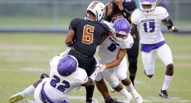 Senators CJ Harris (22) and Quinn Lizmore (8) wrap up Atlantic Coast running back Caleb Green (6) during Fletcher’s 14-7 district win. (photo by Rob DeAngelo)