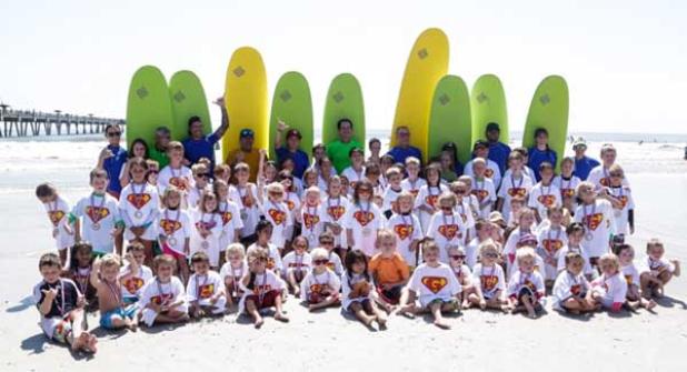 Participants and instructors pose for a photo following the last Super Grom Surf Fest in Jacksonville Beach on June 25. This weekend marks the third and final Super Grom Fest of the summer. (photo by David Rosenblum)