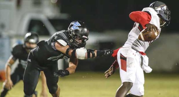 Ponte Vedra Sharks linebacker Trevor Rolison (17)  grasps Parker quarterback Cameron Sapp (10) during the district game last Friday. (photo by David Rosenblum)