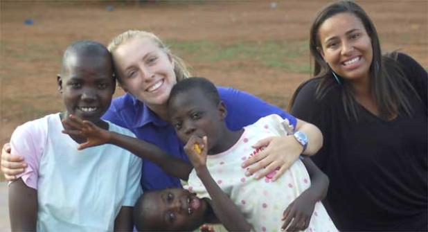 Theatre on a Mission team members Chelsey Cain and Danielle Glenn with children from the orphanage. (photo submitted)