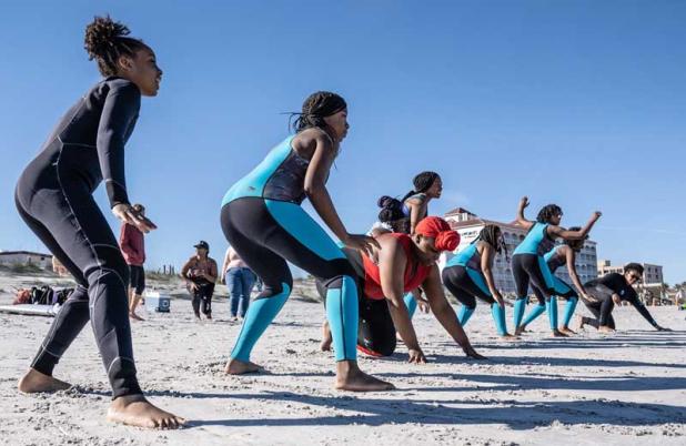 A group of girls participate in a surf camp to learn surfing fundamentals as part of the SurfearNEGRA program. (photo from SURFEARNEGRA.COM)