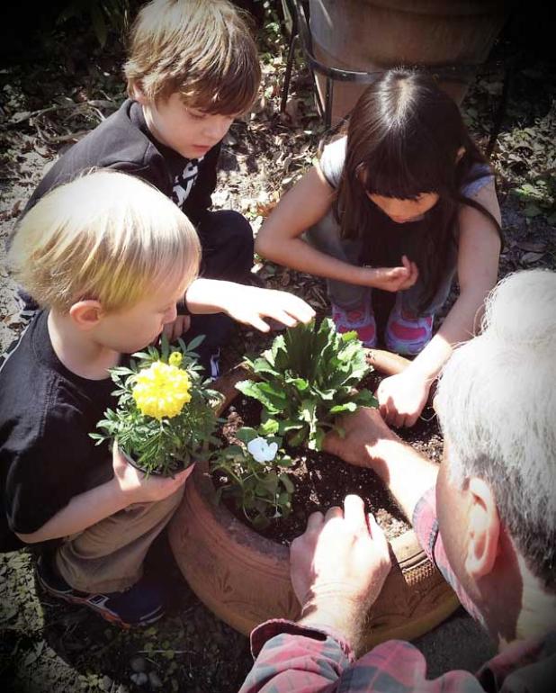 McDonald helps children plant container annuals in a special whimsical section of the garden. (photo submitted)